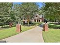 A long driveway leads to a beautiful home surrounded by lush greenery at 100 Old Plantation Way, Fayetteville, GA 30214