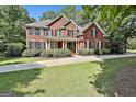 Charming two-story brick home featuring a manicured lawn and inviting front porch at 100 Old Plantation Way, Fayetteville, GA 30214
