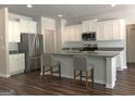 Modern kitchen featuring stainless steel appliances, granite countertops, a kitchen island, and stylish hardwood floors at 85 Crabapple Ridge Dr, Oxford, GA 30054