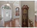 A welcoming entryway with hardwood floors, a decorative grandfather clock, and a view of the bright, arched doorway at 1103 Wilder Ct, Mcdonough, GA 30252