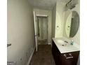 Bathroom with a single sink vanity, an oval mirror, and neutral walls leading to the doorway at 3144 Clemons Rd, Stockbridge, GA 30281