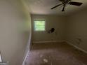 This bedroom has bare walls and floors, as well as a window overlooking the yard at 3144 Clemons Rd, Stockbridge, GA 30281
