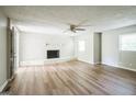 Spacious living room featuring updated flooring, a white-painted brick fireplace, and natural light from the windows at 6770 Burkhead Dr, Union City, GA 30291