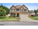 Charming two-story brick home with a front porch, a two-car garage, and a well-manicured lawn at 4770 Macy Way, Ellenwood, GA 30294