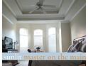 Sunlit main bedroom featuring a tray ceiling, ceiling fan and large bay windows at 30 Cynthia Ct, Fayetteville, GA 30215