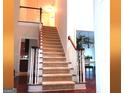 Carpeted staircase with wood banister leads to the upper level, showcasing the home's open floor plan at 30 Cynthia Ct, Fayetteville, GA 30215