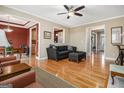 Open concept living room with hardwood floors, a ceiling fan, and views to the dining room at 110 Camford Stone Path, Fayetteville, GA 30214