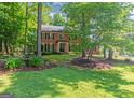 Classic brick home with manicured lawn, professional landscaping, and mature trees at 200 Savannah Walk, Peachtree City, GA 30269
