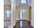 Elegant foyer with hardwood floors, arched doorways, and natural light streaming through the window at 2817 Village Park E Dr, Ellenwood, GA 30294