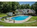 A backyard swimming pool with diving board is surrounded by well-manicured lawn and mature trees at 360 Darren Dr, Fayetteville, GA 30215