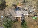 An aerial view of a charming home with dormer windows surrounded by mature trees and lush greenery at 75 Price W Dr, Locust Grove, GA 30248