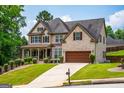 Attractive two-story home featuring a brick facade, attached garage, and a lush green lawn at 4311 Hampton Mill Pkwy, Douglasville, GA 30135