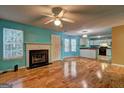 Spacious open-concept living room features hardwood floors, a fireplace, and views into an adjacent kitchen area at 1067 Misty Meadows Pt, Hampton, GA 30228