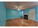 Bright living room boasts a decorative fireplace, hardwood floors, a ceiling fan, and fresh, blue-painted walls at 1067 Misty Meadows Pt, Hampton, GA 30228