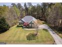 Beautiful aerial view of a home with a spacious yard, complemented by mature trees and a private driveway at 50 Clear Spring Ct, Oxford, GA 30054