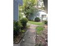 Backyard featuring a lush green lawn, bordered by trees and a stone walkway at 8596 Creekwood Way, Jonesboro, GA 30238