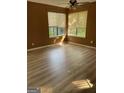 Bright bedroom with wood floors, a ceiling fan, and multiple windows with natural light at 8596 Creekwood Way, Jonesboro, GA 30238