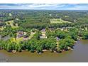 An aerial view showcases lakeside homes nestled among lush greenery, with a golf course in the distance at 660 Milton Dr, Mcdonough, GA 30252