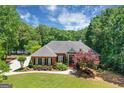 Charming brick home with manicured lawn and landscaping, featuring a beautiful flowering tree in front at 660 Milton Dr, Mcdonough, GA 30252