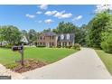 A charming two-story home with a long drive, beautiful yard and lush trees at 127 Rockspray Rdg, Peachtree City, GA 30269