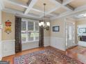 Elegant dining room featuring a coffered ceiling, large window, hardwood floors, and a chandelier at 409 Brandy Ln, Mcdonough, GA 30253