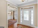Inviting foyer with hardwood floors, decorative front door, and an open view into the dining room at 409 Brandy Ln, Mcdonough, GA 30253