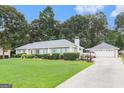 Wide view of the front exterior of a charming house with a well-manicured lawn and a detached garage at 85 London Ln, Sharpsburg, GA 30277
