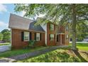 Well-maintained two-story home with a brick facade and a paved walkway, framed by a mature tree at 2326 Sand Dollar Sw Ct, Atlanta, GA 30331