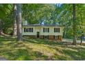 Home exterior featuring a well maintained lawn, dark shutters, and plenty of shade trees at 4496 Housworth Dr, Lithonia, GA 30038