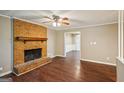 Living room boasts hardwood floors, a ceiling fan, and a large brick fireplace at 4496 Housworth Dr, Lithonia, GA 30038