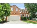 Lovely two-story brick home with attached garage, white trim, and a well-maintained lawn at 1186 Village Ne Cv, Atlanta, GA 30319