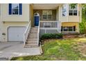 Close-up of home's entryway with a bright blue door, white porch, and a well-maintained lawn at 169 Knights Ct, Dallas, GA 30157