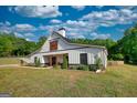 Exterior view of modern farmhouse featuring a covered porch and a well manicured lawn at 540 Benton Rd, Covington, GA 30014
