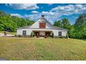 Exterior view of modern farmhouse featuring a covered porch and a well manicured lawn at 540 Benton Rd, Covington, GA 30014