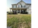 Charming home featuring a welcoming covered porch, enhanced by manicured landscaping at 64 N Village Cir, Rydal, GA 30171