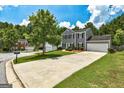 Two-story home with gray siding, black shutters, well-kept lawn and long driveway at 3953 Willow Fields Ct, Loganville, GA 30052