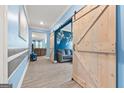 Spacious hallway featuring light gray plank flooring, light blue walls and farmhouse doors at 400 Plainfield St, Fayetteville, GA 30215