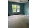 A bedroom with blue walls, a window, and a ceiling fan at 4887 Winterview Ln, Douglasville, GA 30135