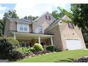 Charming two-story brick home featuring a welcoming front porch and attached two-car garage at 305 Matthew Cir, Stockbridge, GA 30252
