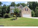 Well-maintained two-story brick home with a two-car garage and lush lawn featuring mature trees at 305 Matthew Cir, Stockbridge, GA 30252