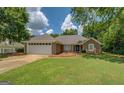 Inviting home with well-maintained lawn, neutral exterior, and attached two-car garage on a sunny day at 1615 Clairmont Sw Ln, Conyers, GA 30094