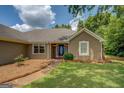 Close-up of house showing entryway with trimmed lawn and tidy landscape surrounding the building at 1615 Clairmont Sw Ln, Conyers, GA 30094