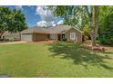 Well-kept home with a spacious front yard, complemented by mature trees and neutral exterior at 1615 Clairmont Sw Ln, Conyers, GA 30094