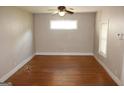 Empty living room features hardwood floors, a ceiling fan, and a window with natural light at 1627 Orlando Sw St, Atlanta, GA 30311