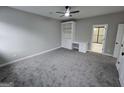Spacious bedroom with plush gray carpet, a ceiling fan, a built-in bookshelf, and an attached bath at 7910 Tintern Trce, Duluth, GA 30097