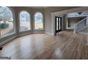 Bright living room featuring large windows, hardwood floors, elegant trim and staircase with white railing at 7910 Tintern Trce, Duluth, GA 30097
