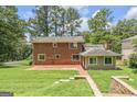 Expansive backyard with brick patio and a lush lawn, perfect for outdoor entertaining and relaxation at 708 Delanie Way, Stone Mountain, GA 30083