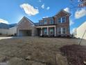 Brick two-story home with white trim, well-manicured lawn and attached garage at 714 Ocmulgee Crossing, Locust Grove, GA 30248