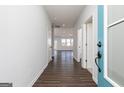 Hallway featuring wood-look floors, light gray walls and open door to living space at 714 Ocmulgee Crossing, Locust Grove, GA 30248
