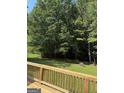 View of the property's spacious backyard from atop a wooden deck and railing at 276 Appalachee Church Rd, Auburn, GA 30011